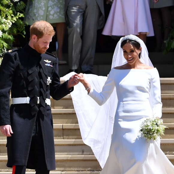 Príncipe Harry ajuda a mulher, Meghan Markle, a descer escadaria da capela