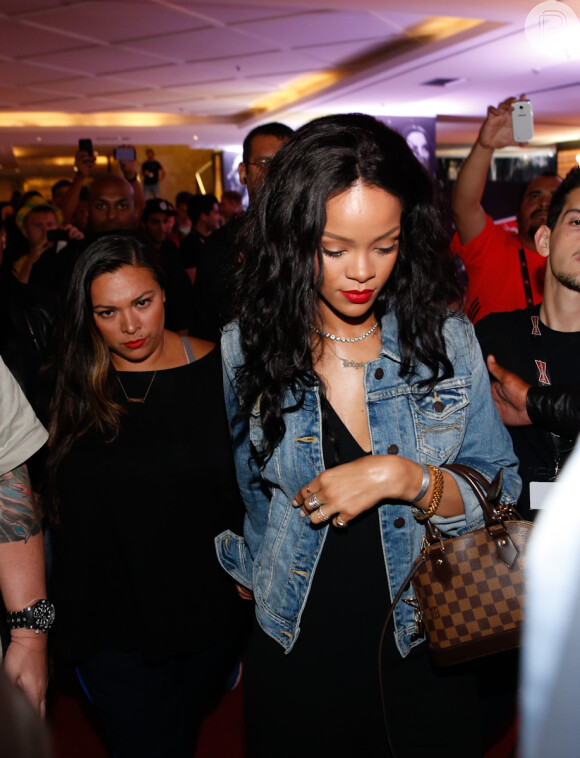 De macacão preto e jaqueta jeans, Rihanna deixa hotel no Rio