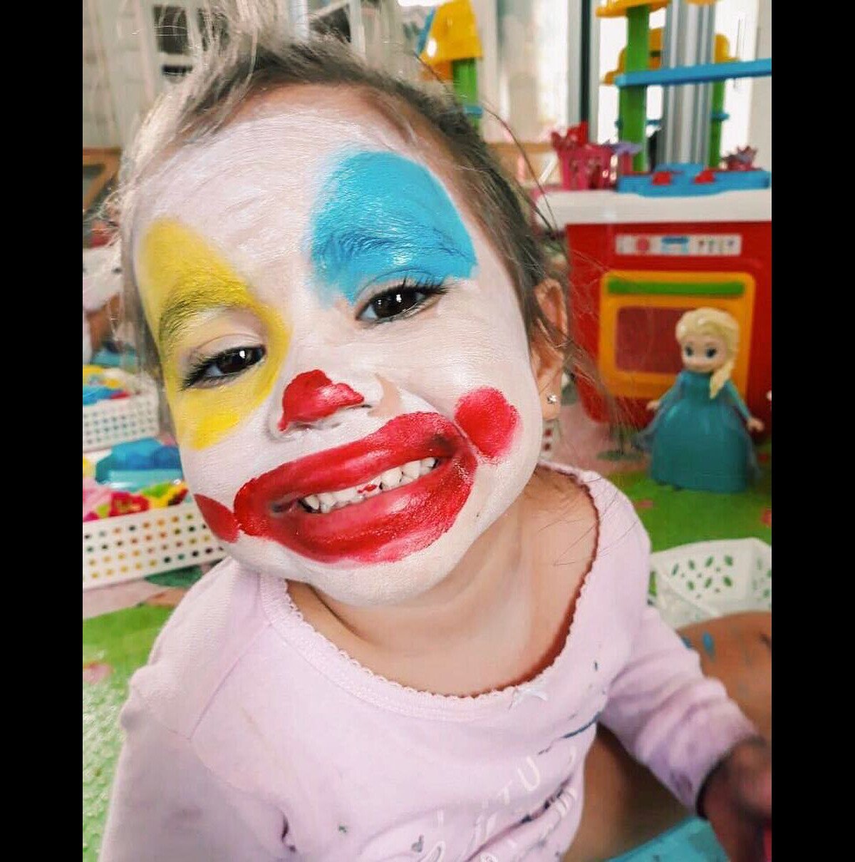 Uma menina com o rosto pintado com tinta preta e branca.