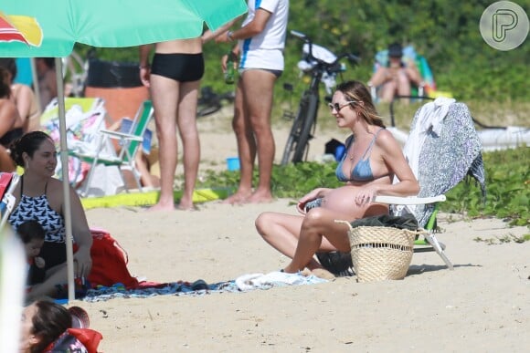 Candice Swanepoel, grávida de 8 meses, tomou sol em praia do Espírito Santo