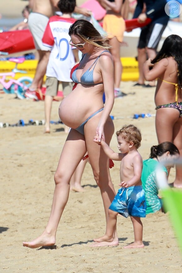 Modelo sul-africana Candice Swanepoel caminhou na areia da praia com Anacã, de 1 ano e 8 meses, seu primeiro filho com o modelo brasileiro Hermann Nicoli