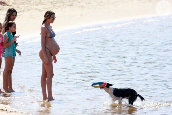 Candice Swanepoel, aos 8 meses de gravidez, brincou com cachorro em praia de Vitória, no Espírito Santo