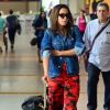 Anitta dobra as mangas da jaqueta Givenchy ao embarcar no Rio