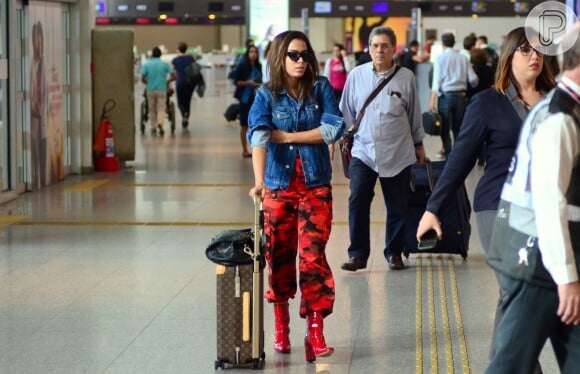 Anitta dobra as mangas da jaqueta Givenchy ao embarcar no Rio