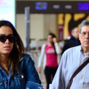 Anitta combinou uma jaqueta jeans com bota vermelha e calça camuflada