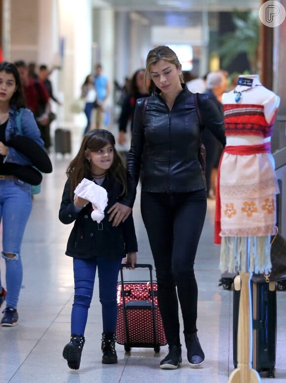 Looks das famosas no aeroporto: Grazi Massafera escolhe skinny em look total black, com jaqueta de couro e tênis para viajar com a filha Sofia, bem prática