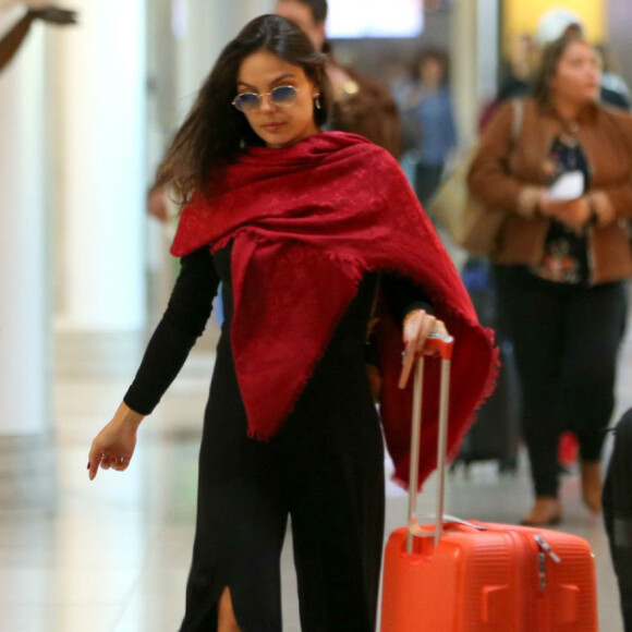 Isis Valverde escolheu macacão com fenda e xale Louis Vuitton para viajar