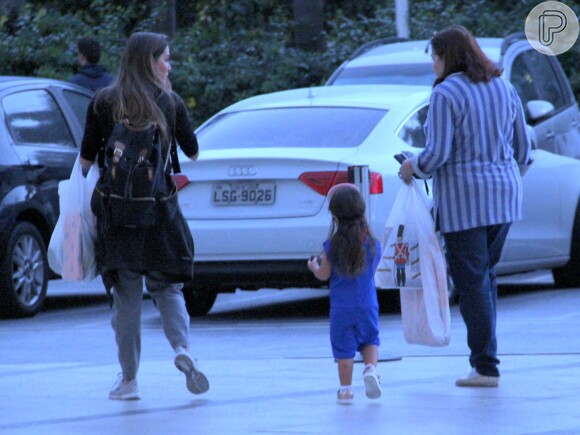 Deborah Secco caminha no estacionamento com a filha, Maria Flor, e a mãe, Silvia