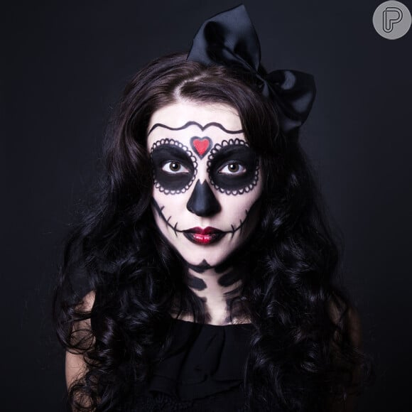 A maquiagem de caveira mexicana para o Halloween pode ser feita com base de maquiagem de tons mais claros do que a pele, batom vermelho e lápis preto