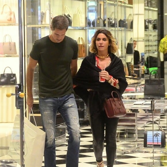 Giovanna Antonelli se refrescou com refrigerante durante passeio em shopping com o marido, Leonardo Nogueira