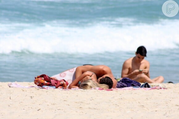Yasmin Brunet e o marido, Evandro Soldati, namoram deitados na praia