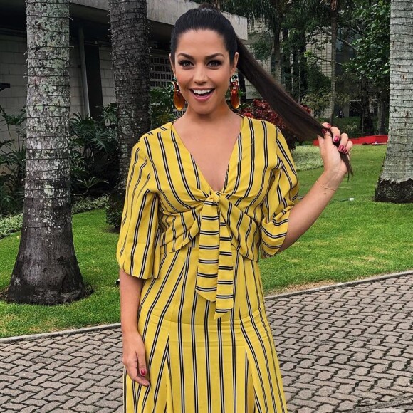 Em foto, Thais Fersoza aparece com vestido midi listrado nas cores amarelo e preto e completou a produção com maxibrincos e rabo de cavalo superalto