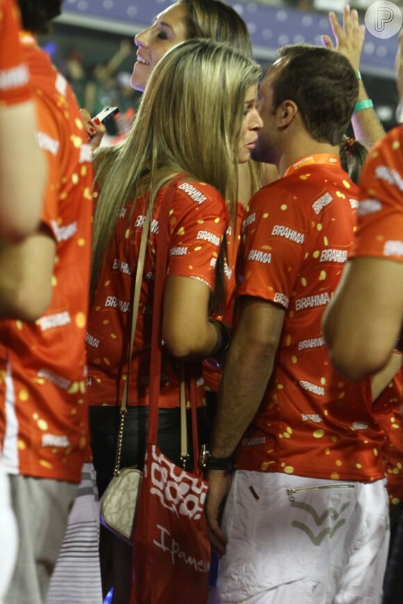 Roger assiste ao desfile das escolas de samba e conversa com uma loira no Sambódromo do Rio