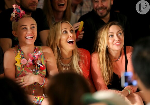 Miley Cyrus se diverte com amigas no desfile do estilista Jeremy Scott