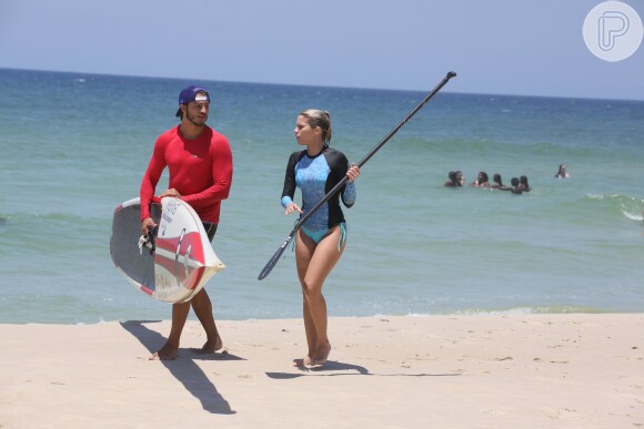 Ao descerem na praia da Barra da Tijuca, Isabella Santoni e o namorado, Caio Vaz, se dividiram para levar o equipamento para a areia