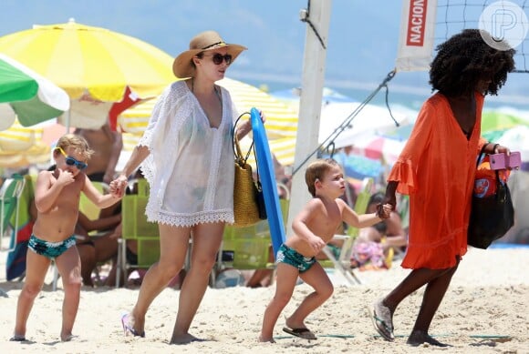 Regiane Alves deixa a praia com os dois filhos