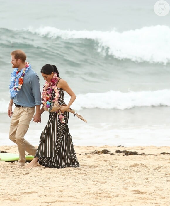 

Meghan Markle rompeu mais uma regra ao ficar descalça em uma praia, na Austrália. Os membros da realeza não devem usar sandálias nem retirar os calçados em público durante os compromissos reais


