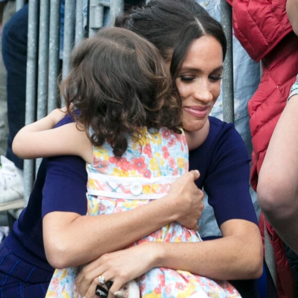 Meghan Markle não poderia demonstrar afeto em público, mas a artista até pediu um abraço a uma menina de dois anos em visita à Nova Zelândia 
