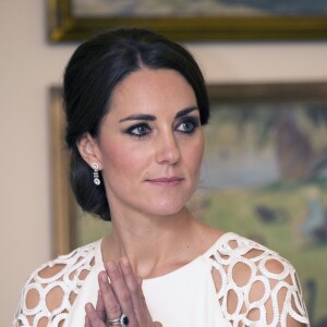 Kate Middleton usa vestido inspitador com mangas vazadas em formas geométricas e acessórios minimalistas. No penteado, um coque volumoso baixo