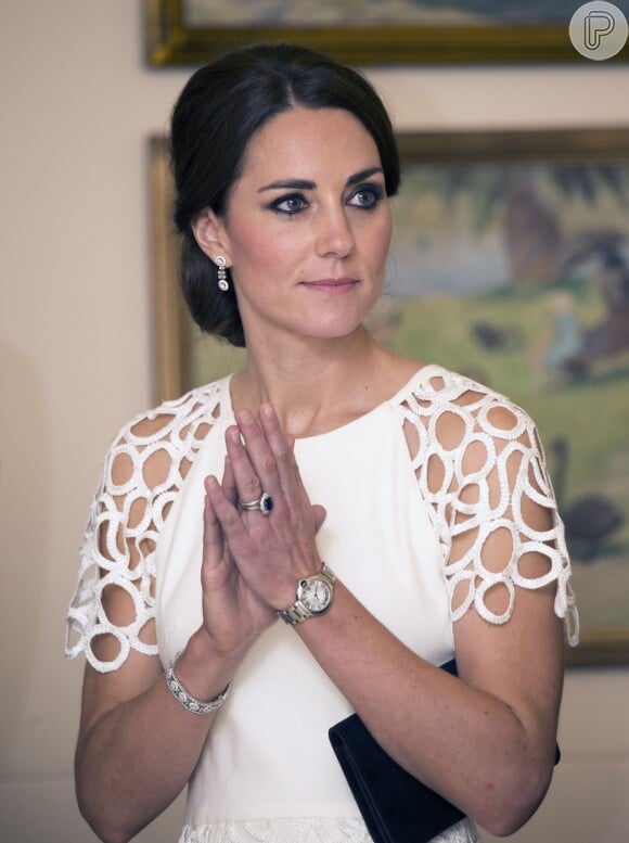 Kate Middleton usa vestido inspitador com mangas vazadas em formas geométricas e acessórios minimalistas. No penteado, um coque volumoso baixo