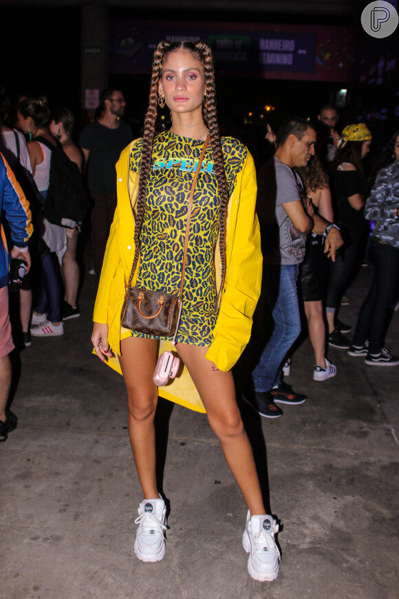 Looks dos famosos do Lollapalooza: Laura Fernandez usou mix de animal print com fundo amarelo, casaco amarelo vibrante oversized e dad sneaker branco. As boxer braids deixaram o visual com mais estilo ainda