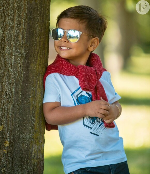 Henry, filho de Simone, dupla de Simaria, deu um toque a mais em seu look ao optar por casaco amarrado no ombro e óculos de sol com as lentes espelhadas. 