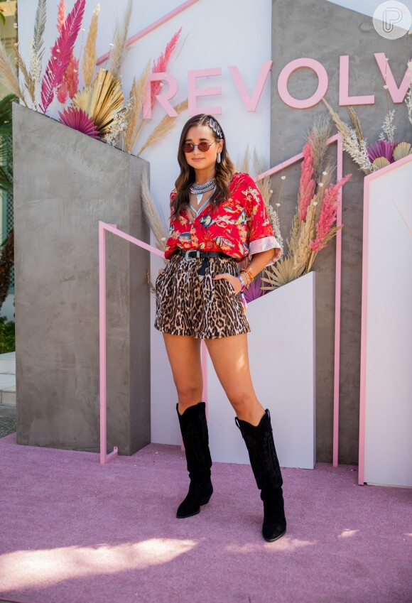 Look Coachella 2019: Mix de animal print e estampa com fundo vermelho com botas western. Detalhe para a trend das presilhas