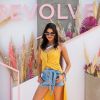Look Coachella 2019: vestido amarelo usado como blusa mulet, shortinho jeans com amarrações e botinha western para complementar o visual
