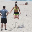 Anitta salta obstáculo durante exercício na praia da Barra da Tijuca
