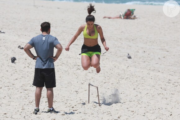 Anitta salta obstáculo durante exercício na praia da Barra da Tijuca