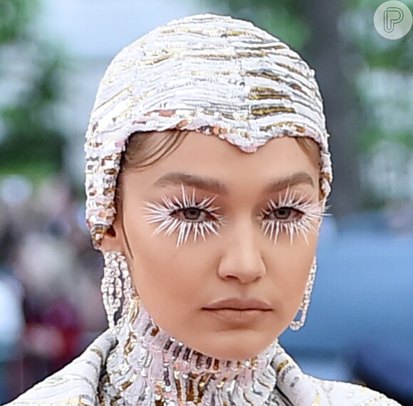 Gigi Hadid optou por uma touca cravejada de cristais em tons de branco, prata e dourado para o seu look pra lá de futurista