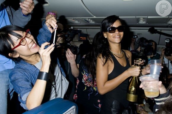 Rihanna distribuiu champanhe para os fãs que estavam com ela no avião. A musa fez sete shows em sete cidades diferentes para divulgar o sétimo CD dela