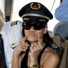 Rihanna pega o chapéu do piloto emprestado para posar na festa que fez com fãs em um avião, em Los Angeles, em 2012