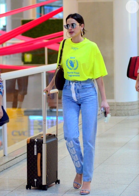 Bruna Marquezine embarca com blusa neon Balenciaga, jeans Off-White e mala grifada em outubro de 2018