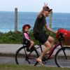 Michel Teló acena para fotógrafo durante passeio de bicicleta com a filha, Melinda