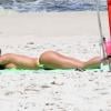 Nicole Bahls desamarra o biquíni para se bronzear na praia da Barra da Tijuca, no Rio