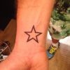 Otaviano costa tatua uma estrela no pulso