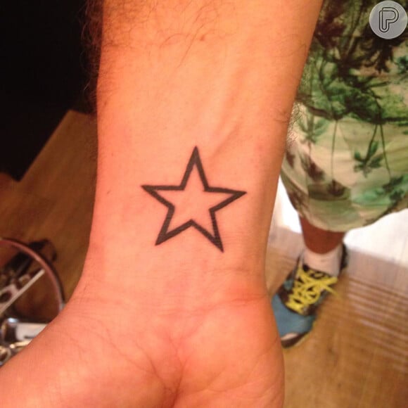 Otaviano costa tatua uma estrela no pulso