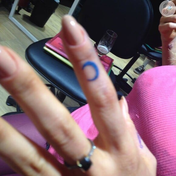 Flávia Alessandra tatua uma lua no dedo indicador