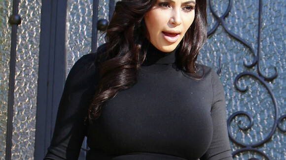 Kim Kardashian, grávida, opta por look justinho: blusa curta e calça de babados