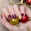 O esmalte dourado na nail art filha única ajuda a criar um visual natalino com esmaltes escuros