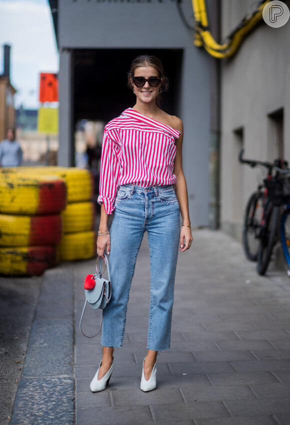 Calça jeans na moda: a camisa social listrada pode ganhar mais informação de moda quando usada de trás para frente, imitando uma blusa de um ombro só