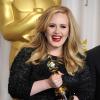 Adele sorri segurando o seu troféu na 85ª cerimônia do Oscar, no Dolby Theatre de Los Angeles, em 24 fevereiro de 2013
