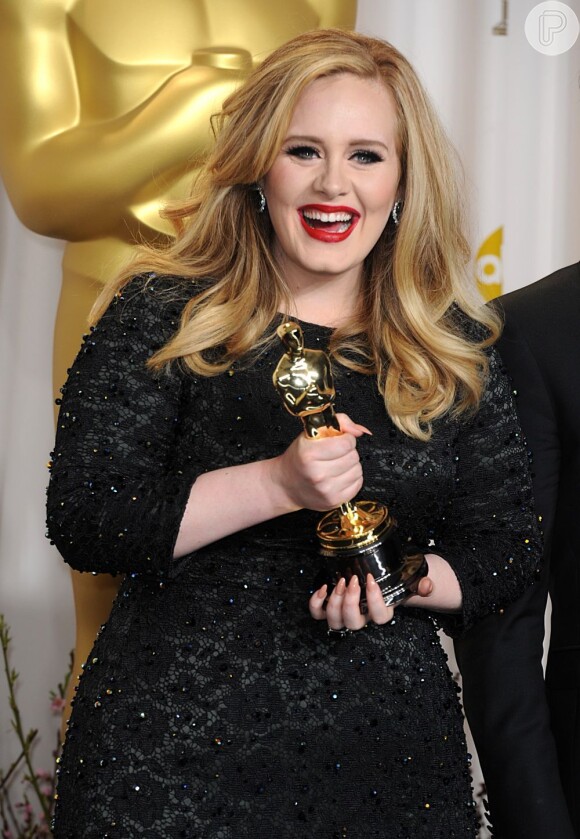 Adele sorri segurando o seu troféu na 85ª cerimônia do Oscar, no Dolby Theatre de Los Angeles, em 24 fevereiro de 2013