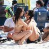 Isis Valverde e o marido, André Resende, se beijam em momento de lazer na praia
