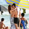 Isis Valverde, antes de sair da praia, beija o marido, André Resende