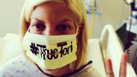 Tori Spelling, isolada com suspeita de Ebola, posta foto com máscara cirúrgica
