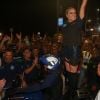 Claudia Leitte acena para o público em cima da moto de policial antes de subir no trio