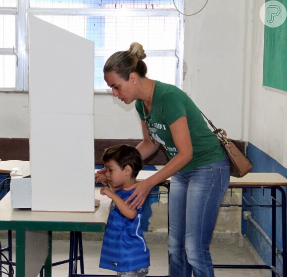 Juliana Silveira chega para votar com o marido, João Vergara, e com o filho, Bento