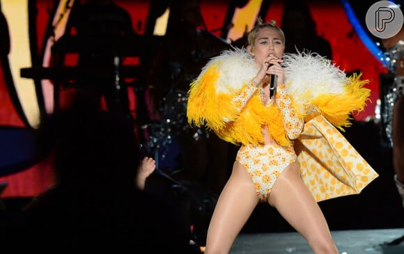 A cantora optou pelo clássico body cavado, desta vez de cor amarela com estampas. Miley usou acessórios da mesma cor para compor o figurino da turnê 'Bangerz', realizada em São Paulo